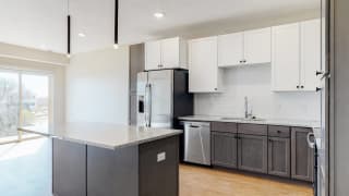 Bliss (1 bed, 1 bath) in Slate finish Beautiful kitchen completed with two tone slate finishes, including pendant lighting and stainless steel appliances in the Bliss floor plan at Haven at Uptown in Lincoln, NE