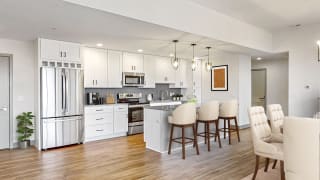 Create your culinary masterpiece in this chef&#x2019;s kitchen with seated island, stainless steel appliances, granite counter tops and custom tile backsplash in this 2 bedroom penthouse floor plan at Midtown Crossing Apartments Omaha.