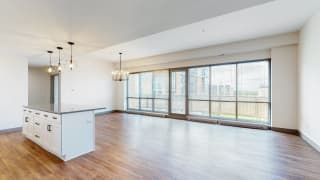 Enjoy the scenic views from the floor-to-ceiling windows in the dining and living area of a 2 bedroom penthouse floor plan at Midtown Crossing Apartments Omaha