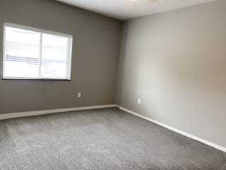 Large carpeted bedroom with window The Flats at Shadow Creek in Lincoln Nebraska