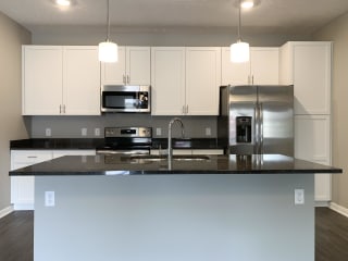 Kitchen with white cabinets and dark granite counters The Flats at Shadow Creek in Lincoln Nebraska