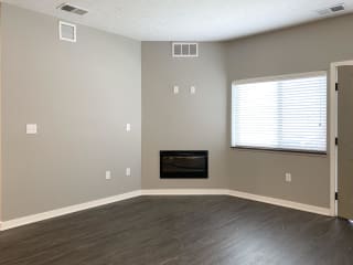 Living room area with electric fireplace on the center wall