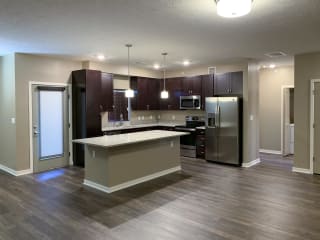 Kitchen with dark brown cabinets and large kitchen island and matching stainless steel  appliances