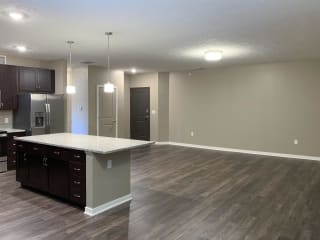 Large living and dining area with hardwood floors and a granite kitchen island