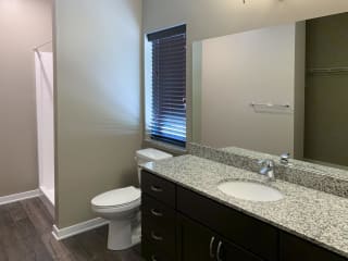 Bathroom with dark brown vanity and large mirror