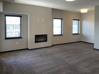 Living room area with electric fireplace on the center wall