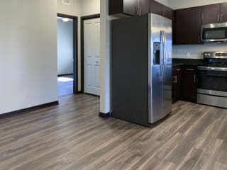 Stainless steel fridge with hallway to master bedroom