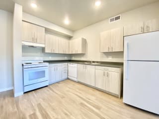 2 bed 2 bath kitchen with stove, range hood, and refrigerator