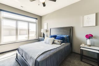 Bedroom with large window and ceiling fan at 360 at Jordan West in West Des Moines, IA