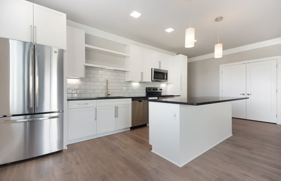 a kitchen with white cabinetry and black countertops