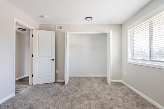 a bedroom with a closet and a large window