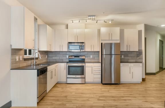 Apartment Kitchen with Excellent Lighting, Hardwood Flooring, and Stainless Steel Appliances at ArtHouse in Seattle 98121