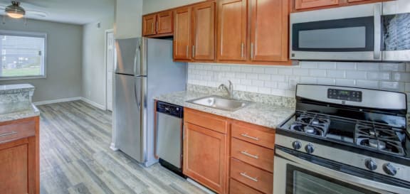 Premium 2 Bedroom Apartment Kitchen with medium wood cabinets, stainless steal appliances and wood like flooring.