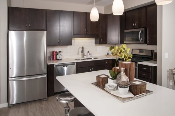 Stylish and bright kitchen with espresso cabinetry, granite countertops, and stainless steel appliances.