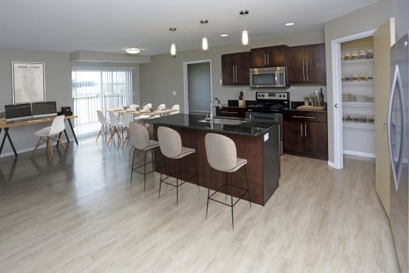 Open concept kitchen with large kitchen island and overhead pendant lighting.