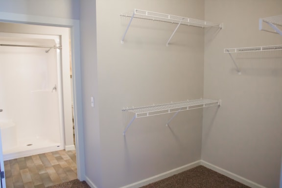 Walk in closet with several levels of shelves, empty