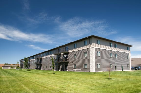 Exterior of Southpoint Apartments showcasing the lush green grounds as well as the balconies and patios available in select units.