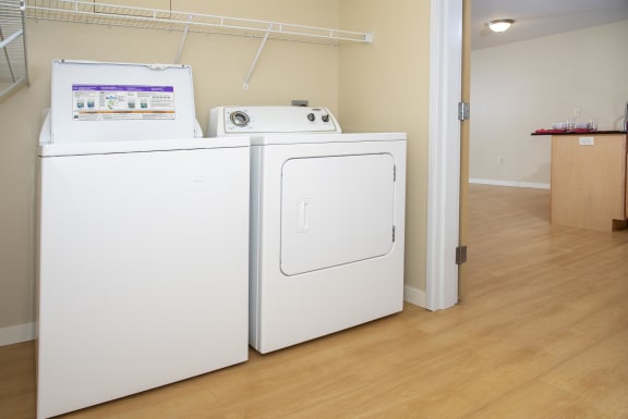 In unit washer and dryer side by side with shelf storage above.