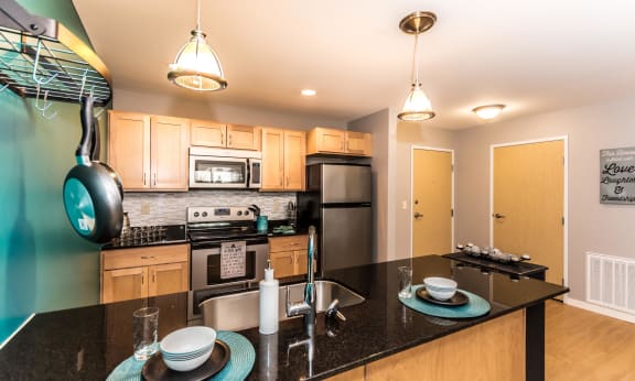 Spacious kitchen with stainless steel appliances, sleek black appliances, and plenty of cabinet storage.