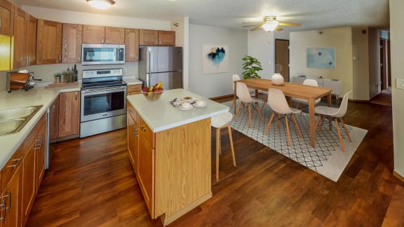 Open and contemporary layout with dining room flowing into the kitchen. There are stainless steel appliances as well as an island.