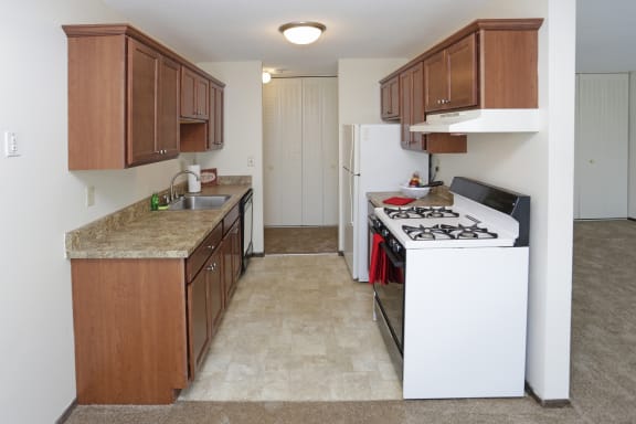 Full kitchen with dark wood cabinets, white appliances