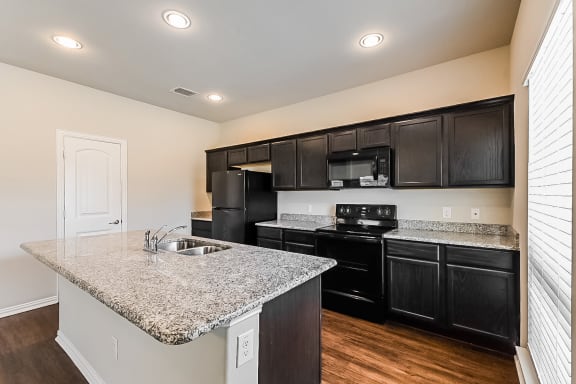 Kitchen with cabinets and appliances at Brooklyn Village Forney, Texas