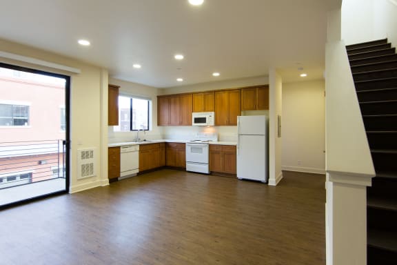 Roundhouse Place Two and Three Bedroom Open Living and Kitchen Area with Sliding Door to Patio