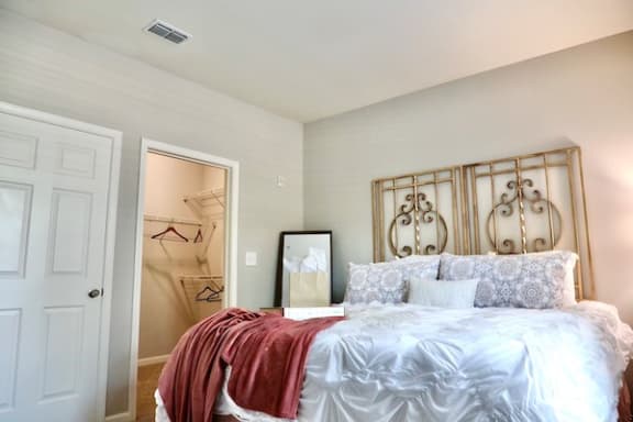 High ceiling in guest bedroom with large closet and model furniture