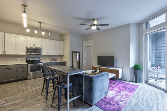 a kitchen and living room with a large window and a sliding glass door
