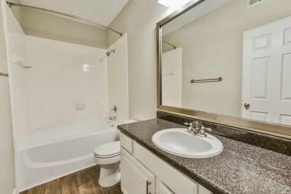 Bathroom with sink, mirror, and tub