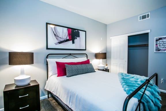Bedroom with large bed, wall art, end tables, and table lamps.