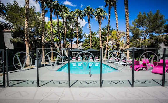 Fenced in pool area with lush landscaping and resort style pool.