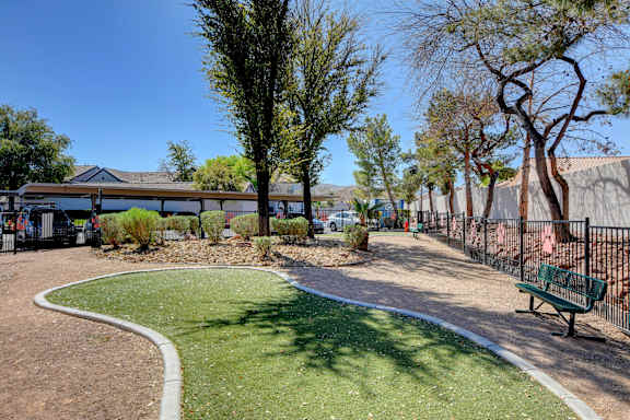 Dog park with grassy area, benches and waste station.