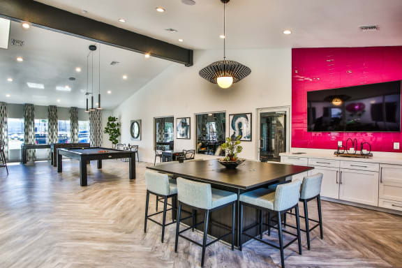Club house with seating areas, gaming area and a kitchen.