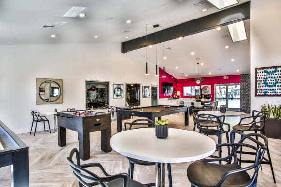 Club house with bistro table with two chairs and gaming tables in the background.