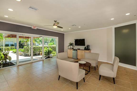 Club house with seating area with a couch, two arm chairs, and a coffee table.