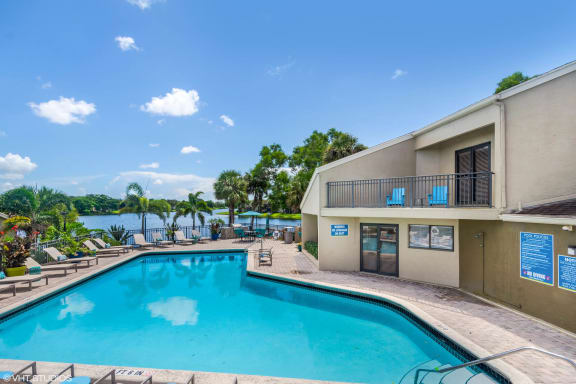 View of Swimming Pool, Sundeck, and Lake at Water&#x27;s Edge Apartments, Sunrise, Florida