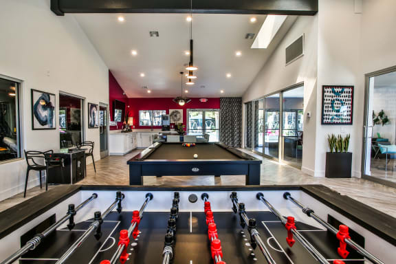 Foosball table and pool table in the club house with the kitchen area in the background.