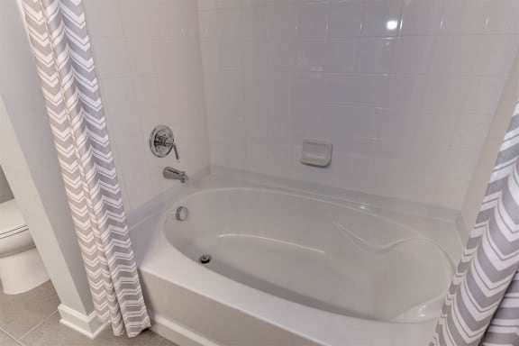 a white bath tub sitting next to a white toilet at Aspire Apollo, Camp Springs, 20746