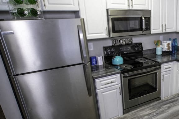 stainless steel fridge, oven, and built-in microwave in kitchen at The Mills at 601, Alabama