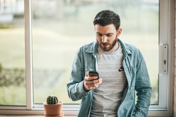 Resident Checking His Phone at River Pointe Apartments