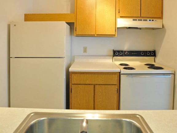 White kitchen appliances at Charter Oaks Apartments in Davison, MI