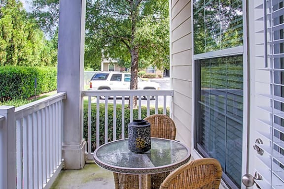 Model deck with outdoor table and chair set at Centerville Manor Apartments, Virginia Beach, VA, 23464