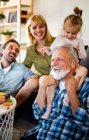 Grandpa Giving Young Girl Piggyback ride in front of parents