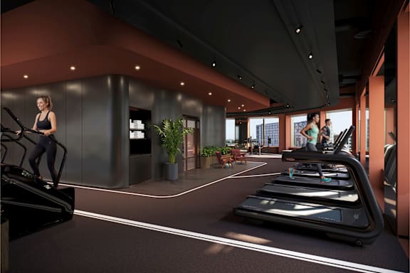 A woman is working out on a treadmill in a modern gym.