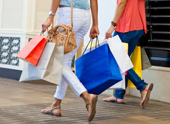 Two women walking with shopping bags.