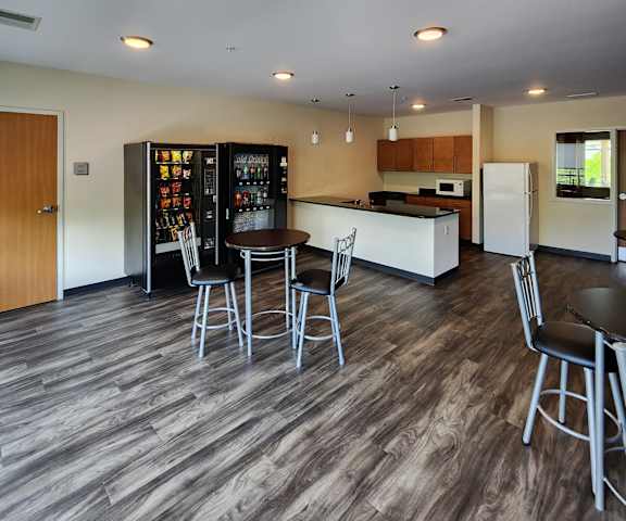 A modern kitchen with a wooden floor and white walls.