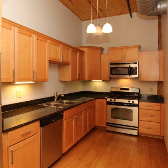 a kitchen with wooden cabinets and stainless steel appliances