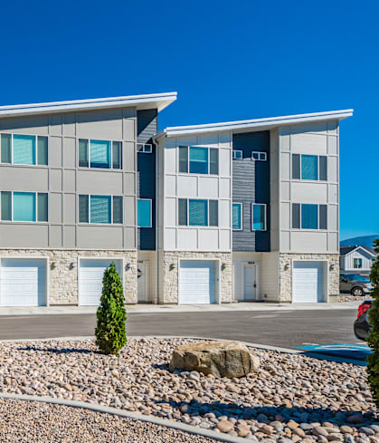 Riverwalk Townhomes Exterior Building with Garages and Lush Landscaping