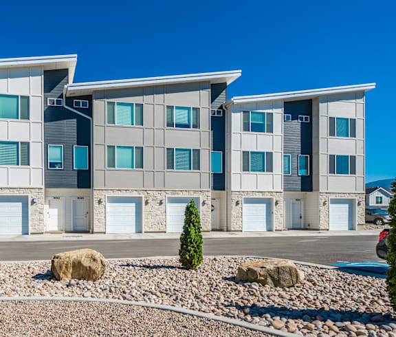 Riverwalk Townhomes Exterior Building with Garages and Lush Landscaping